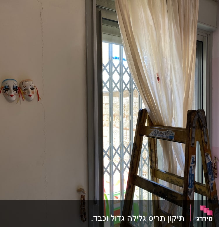 חלון עם תריסים סגורים ומסגרת מתכתית